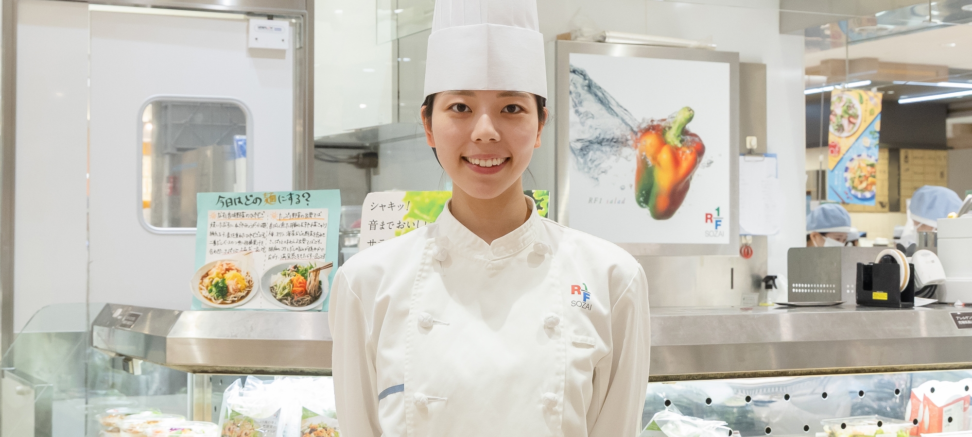 RF1の店舗前で正面向き笑顔で立っているフリータースタッフの写真